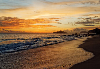 romantic sunset on beach at seychelles island glittering surf and ocean water
