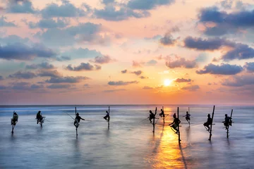 Foto op Aluminium Fishermen on stilts in silhouette at the sunset in Galle, Sri Lanka © MehmetOZB