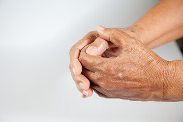 Fototapeta premium Senior woman's wrinkled hand on white background . Old hands of senior lady with freckles and clearly visible veins reaching