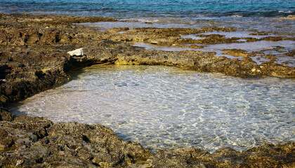 The texture of the rocky coast and the transparent Mediterranean Sea