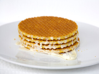 Waffles with condensed milk on a white background