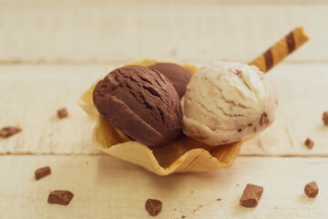 Scoops of ice cream on wooden background