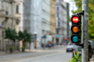 traffic control semaphore with red light on a defocused city background