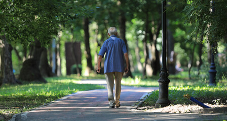 old man walking in summer park