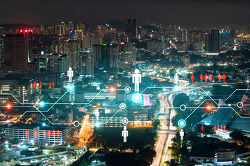 Glowing Social media icons on night panoramic city view of Kuala Lumpur, Malaysia, Asia. The concept of networking and connections between people and businesses in KL. Double exposure.