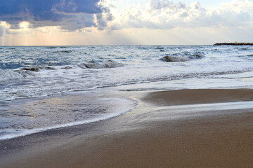 Tropical beach with colorful sunset, cloudy sky. A copy of the space