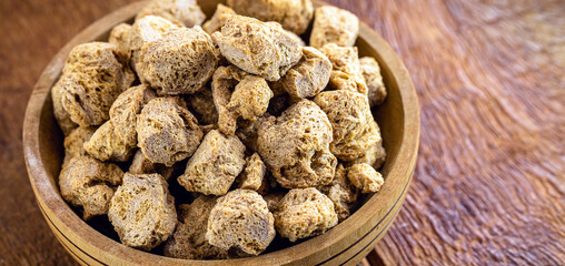 Granulated PINK SOY PROTEIN. Soy based protein on rustic wooden background.