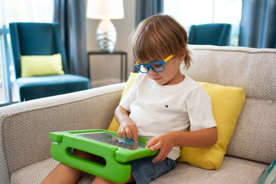little boy playing a video game wearing blue light blocking glasses