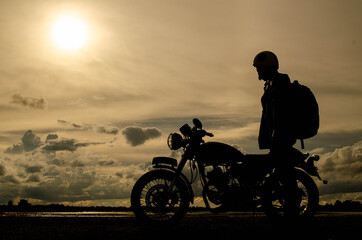 Plakat Silhouette Man Standing By Motorcycle Against Sky During Sunset