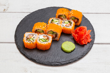 orange tobiko roll on a black slate