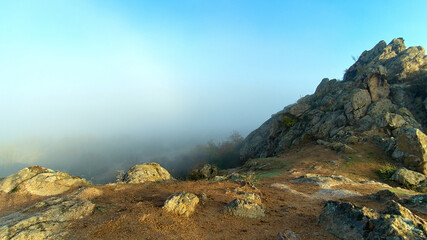 Fototapeta na wymiar Misty dawn on the from pile of huge stones of rocks in the autumn