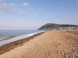 The Irish Sea seascape with the Bray Head mountain on the horizon. Warm and sunny day on the beach.