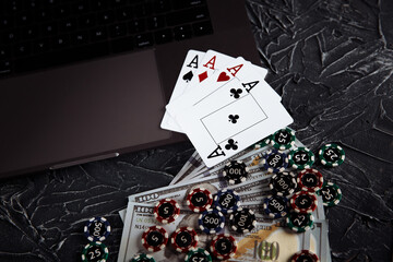 Online poker casino theme. Gambling chips and playing cards on grey background.