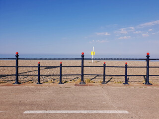 The Bray Seafront with horizon and the Irish Sea visible across the barrier. Seascape. Sunny day. Geometry and visual symmetry.