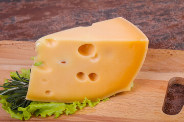 Maasdam cheese  in the board served salad leaves