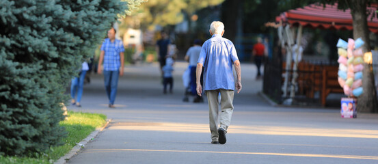 old man walking in summer park