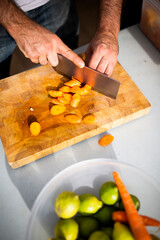 Closeup of hands chopping vegetables.