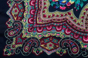 horizontal top view closeup part of floral and paisley pattern on dark cotton scarf