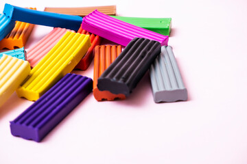 Plates of multi-colored plasticine. Photo of plasticine on a pink background.