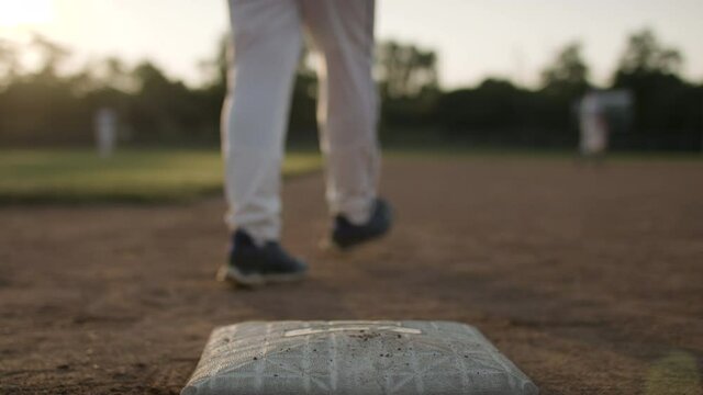 Close call! Running to the plate a baseball player touches the bag on a close call. Athletes and competition in action. Pushin on the plate shot in slow-motion and in 4k. 