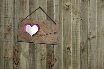 Old fence background with hanging antique wooden board with paper heart. Horizontal
