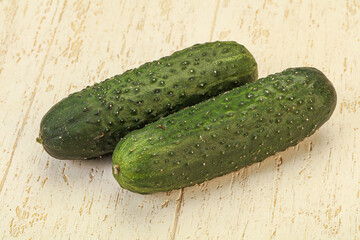 Green fresh cucumbers over background