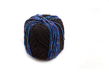 Spool of black threads with blue beads for making bijouterie, embroidery, handmade jewelry. Isolated on white background.