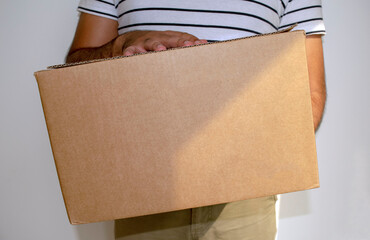 Man is holding cardboard box delivery parcel. Online shopping and Express delivery. Delivery man.