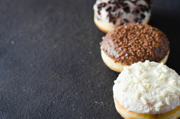 Traditional donut day. Assorted donuts with chocolate glazed on concrete background.