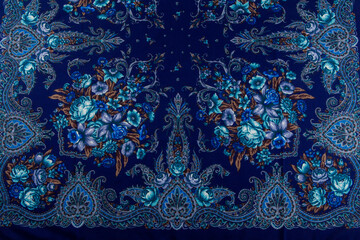 horizontal top view part of blue paisley floral pattern on dark cotton female shawl