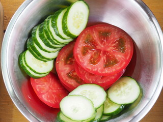 cucumber and tomatoes cut into circles on a wooden Board. use of vegetables