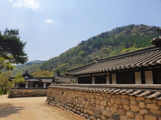 Traditional Korean building near a forested mountain