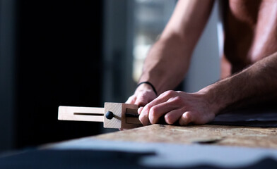 craftsman hands cutting the leather