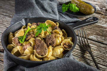 Italian pasta shells with beef sauce in cast iron pan.