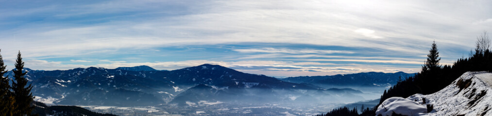Obraz na płótnie Canvas clear blue panorama in the austrian alps with clouds and fog on a cold winter day