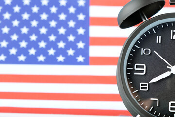 Close up of retro analog clock on USA american flag background.