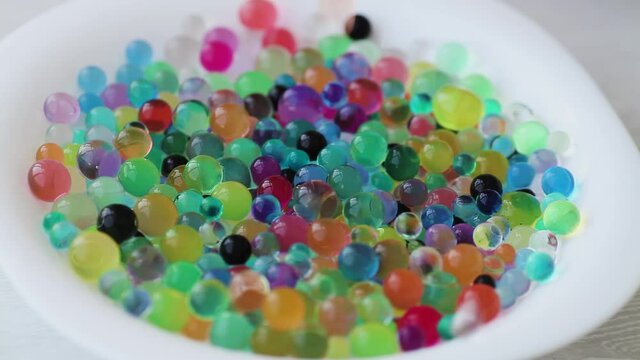 Orbiz sprinkled on top of a white plate. Decoration of water balls with hydrogel - orbeez.