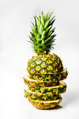 Artistically sliced, standing, delicious pineapple on a white background, isolated, vertical shot.