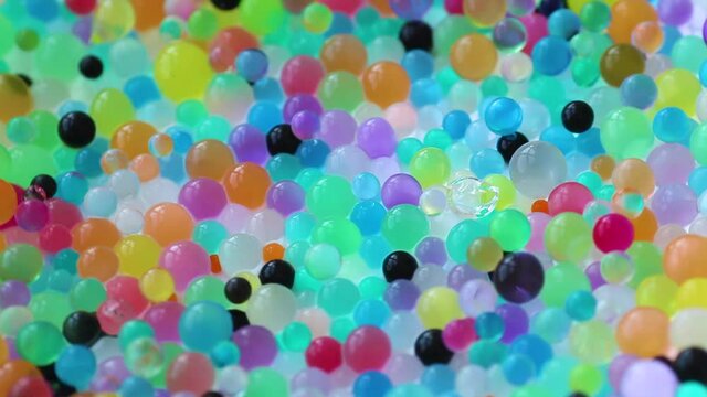 Orbizes rotate in different directions. Decoration of water balls with hydrogel - orbeez.