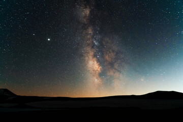 Naklejka na ściany i meble Beautiful starry sky with mountais silhouete, milky way galaxy. Night landscape. Astronomical background. Night photography.