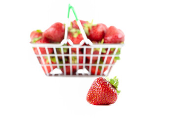 Fresh ripe strawberries in a mini shopping trolley isolated on a white background. Concept of a...