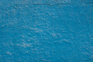 background of an old embossed plastered blue painted wall close up