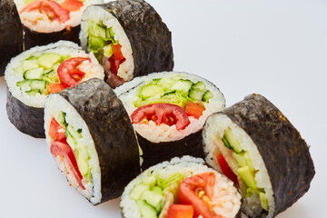Vegetarian sushi rolls with cucumber, sweet pepper, avocado and lettuce on a white background