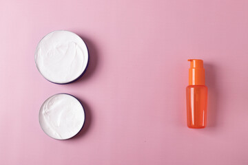 Obraz na płótnie Canvas different cosmetic products for skin, body or hair care on pink background. flat lay, minimalism