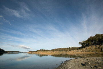 Outdoors. The lake in the forest under a beautiful dramatic sky. The perfect reflection of the environment in the pure water surface.