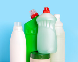 Bottles of cleaning products for the home on a blue background. Cleaning of the apartment. Detergent for dishes, toilet, powder, bleach