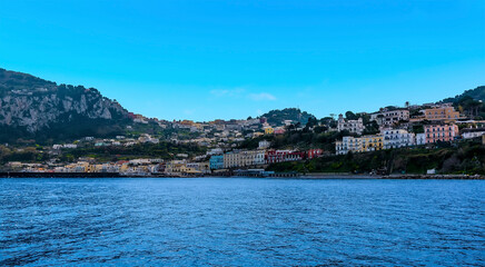 Fototapeta na wymiar Capri town peeps out from the hilltop above Marina Grande on the island of Capri, Italy