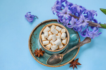 Cup of coffee with blue hyacinth on a blue background