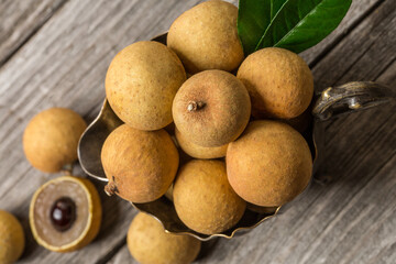 Ripe longan on an old wooden background. Exotic fruit