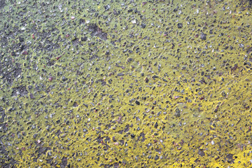 gray granular asphalt with a bright gradient of yellow paint. rough surface texture
